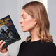 Rosamund Pike holding a copy of The Eye of the World.